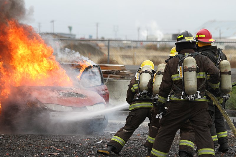 firefighters with burning car
