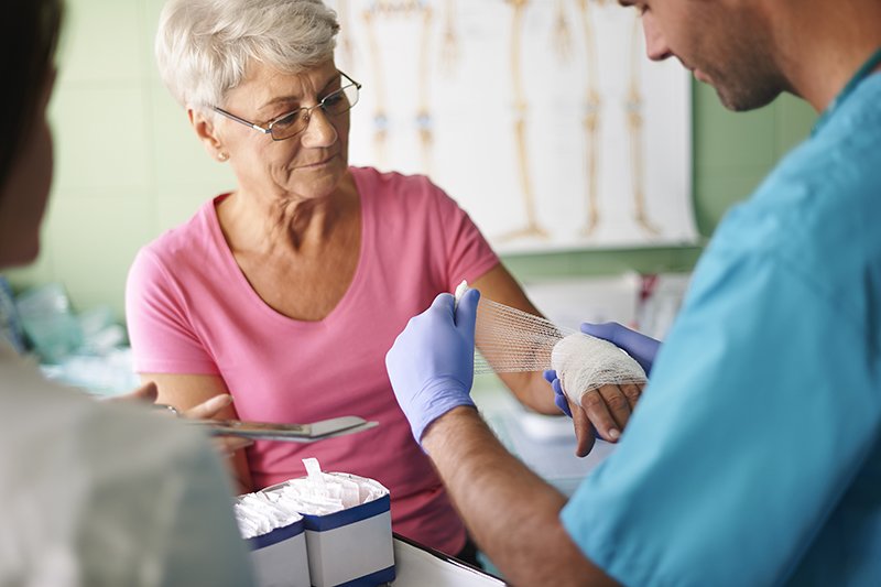 medical assistant wrapping a wound