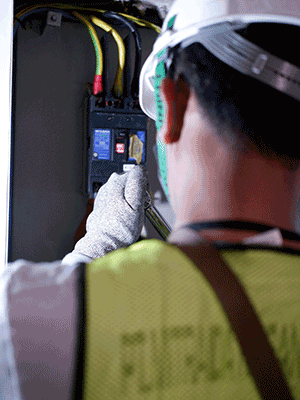 limited electrician inspecting a power board
