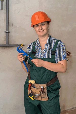 woman working on a plumbing project in a hard hat with tool belt