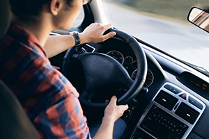 Young adult driver behind the wheel of a car