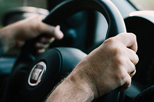view of a person using the steering wheel of a car