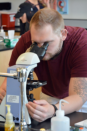 student looking through a microscope