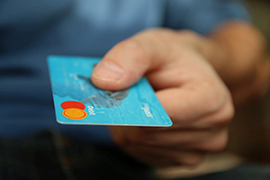 a person's hand reaching out with a credit card to make a payment
