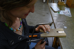 Student metalsmithing in a jewelry-making class
